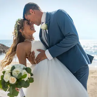 Bride and groom smiling at each other on the beach at Wyndham Alltra Riviera Nayarit, Puerto Vallarta