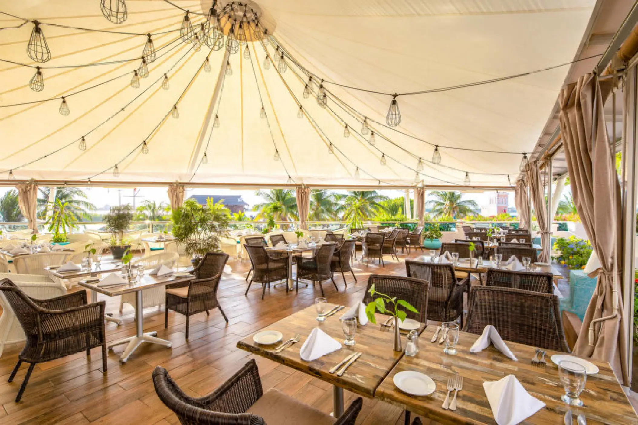Outdoor terrace restaurant with string lights and woven chairs at Sunscape Cancun