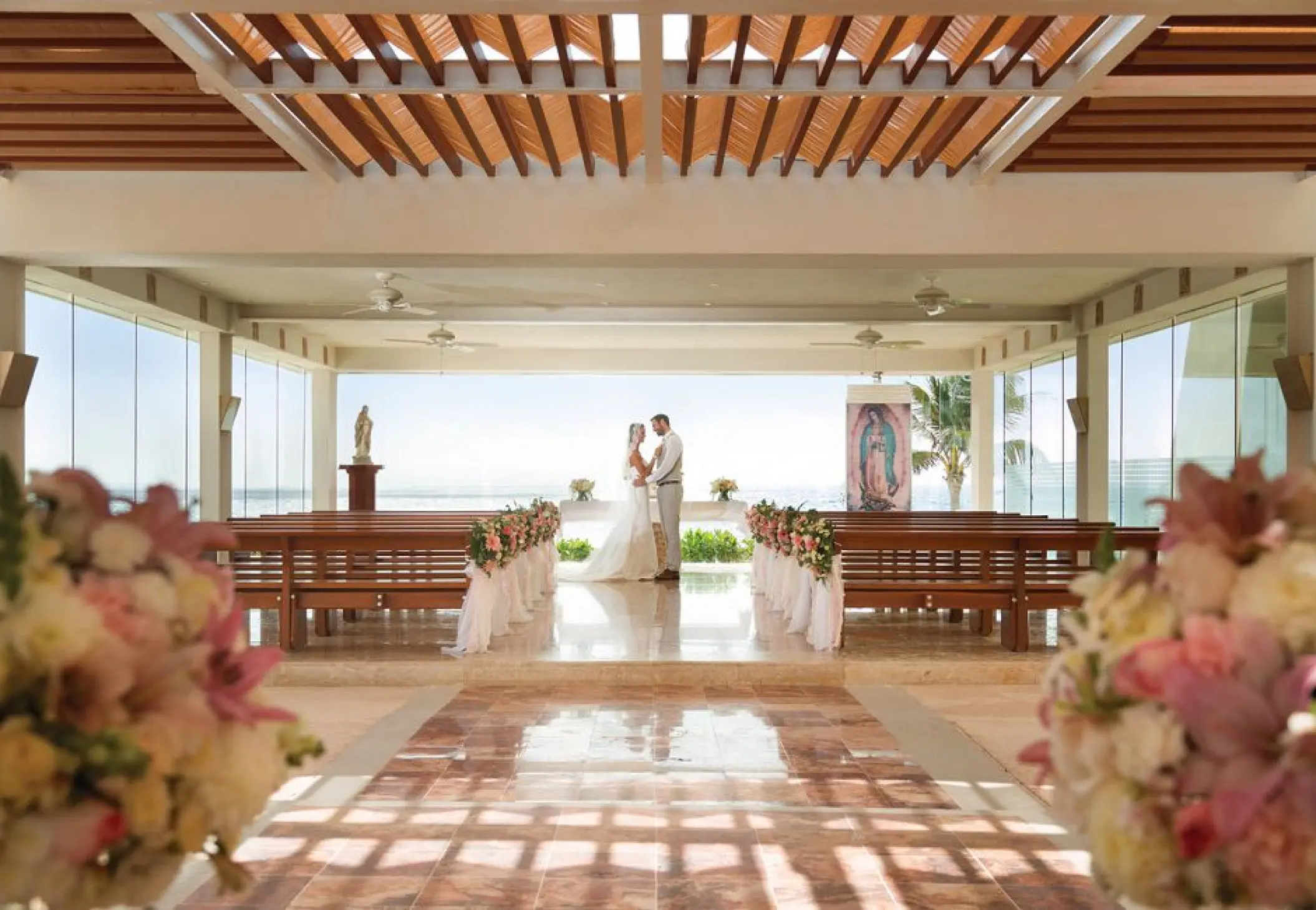 The bride and groom standing at the altar of a wedding chapel at Sunscape Cancun, Cancun