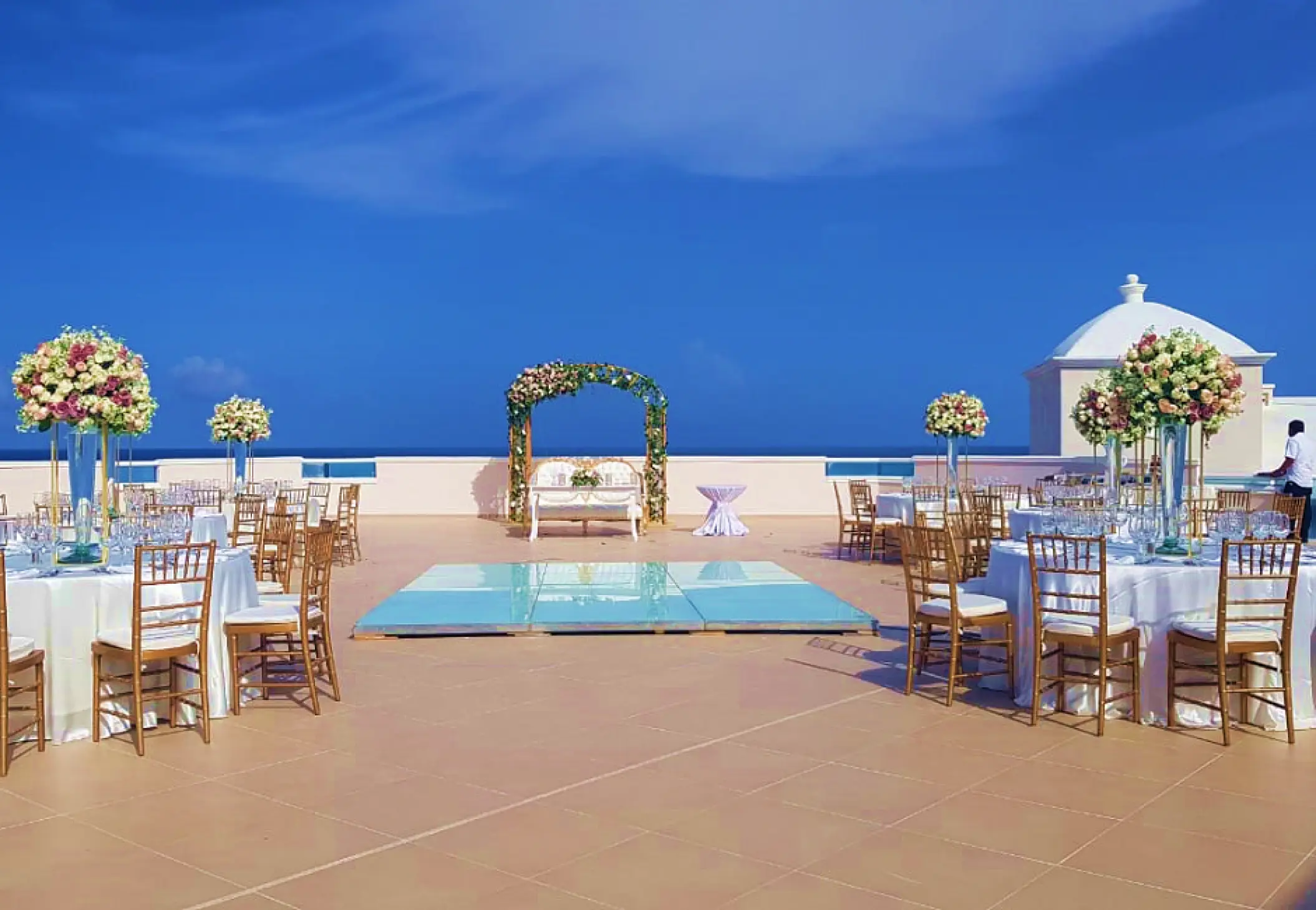 Rooftop wedding reception with dance floor and floral centerpieces at Sunscape Cancun, Cancun