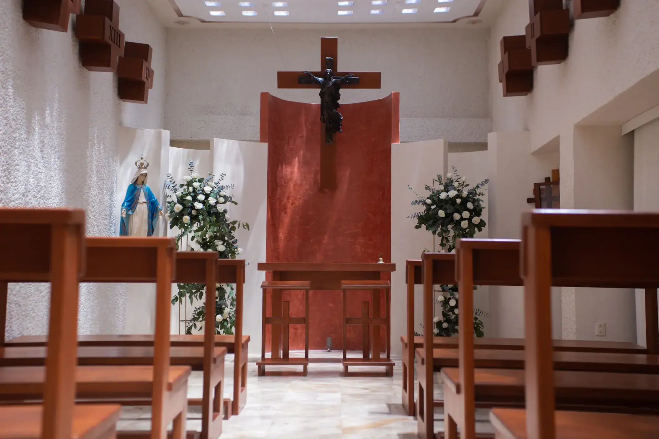 Indoor wedding ceremony chapel with wooden pews and altar at Sunscape Cancun, Cancun