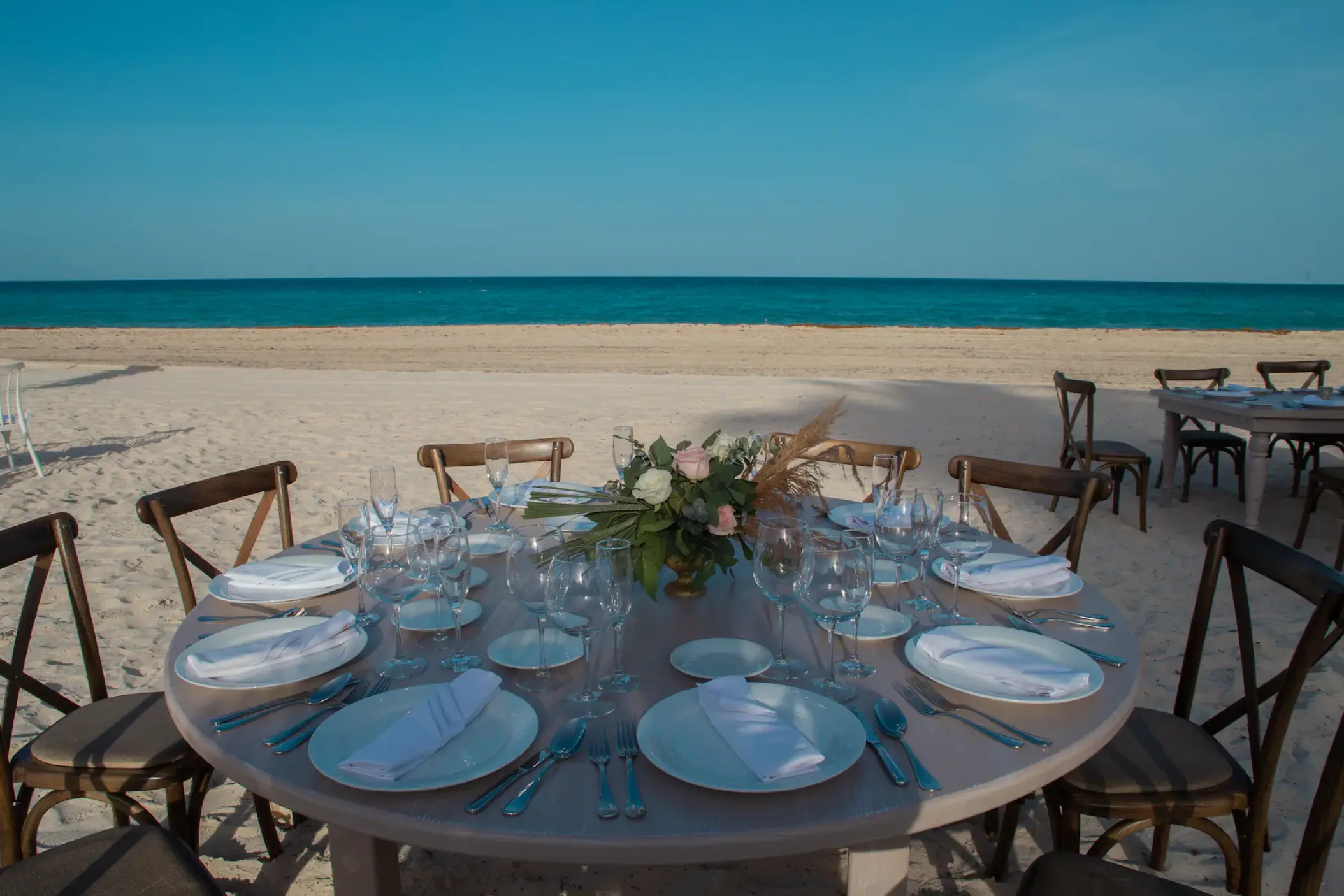 Beachfront wedding reception table with floral centerpiece at Sunscape Cancun