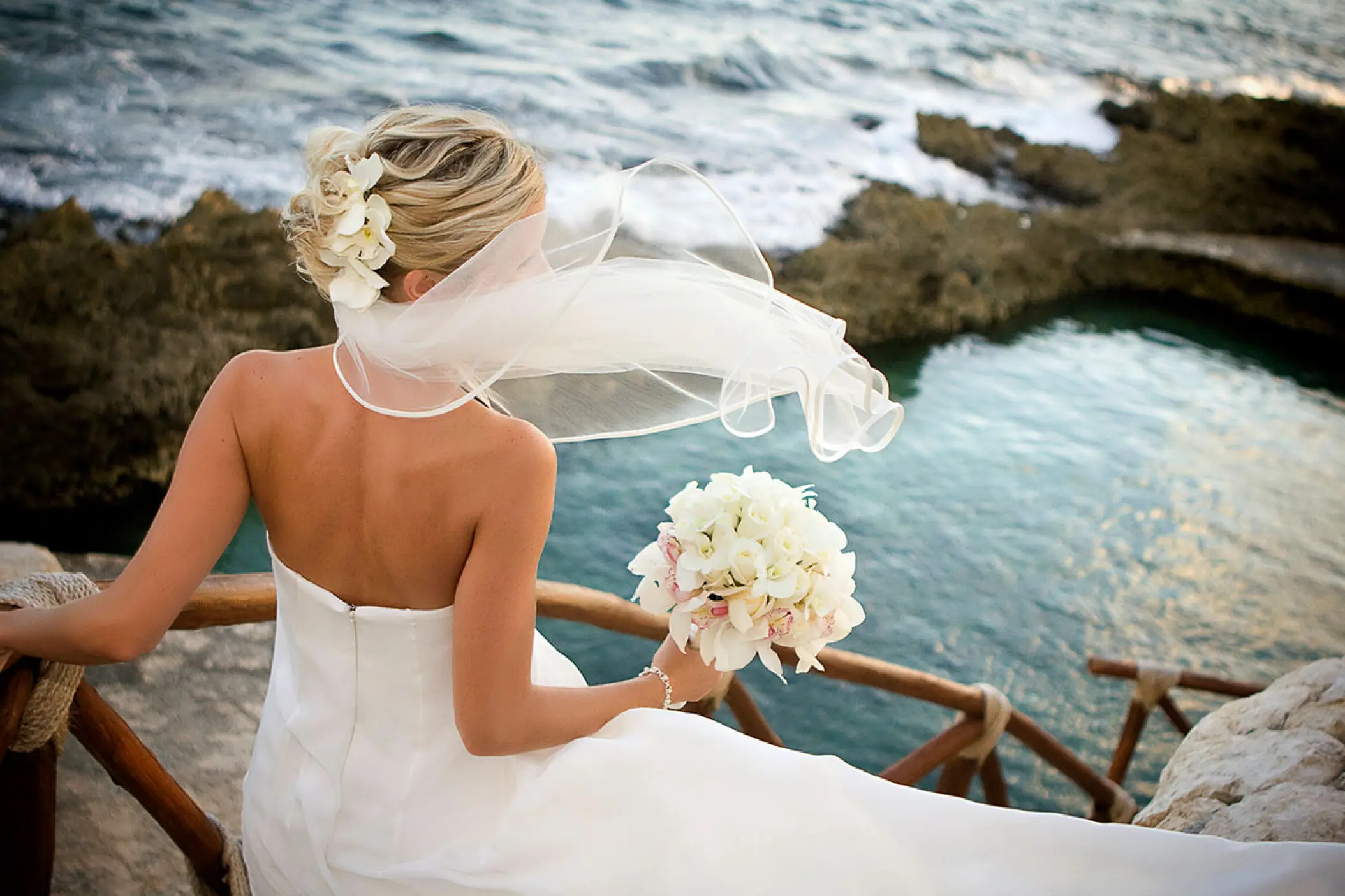 Bride with a white bouquet overlooking the ocean at Hotel Xcaret Mexico, Riviera Maya