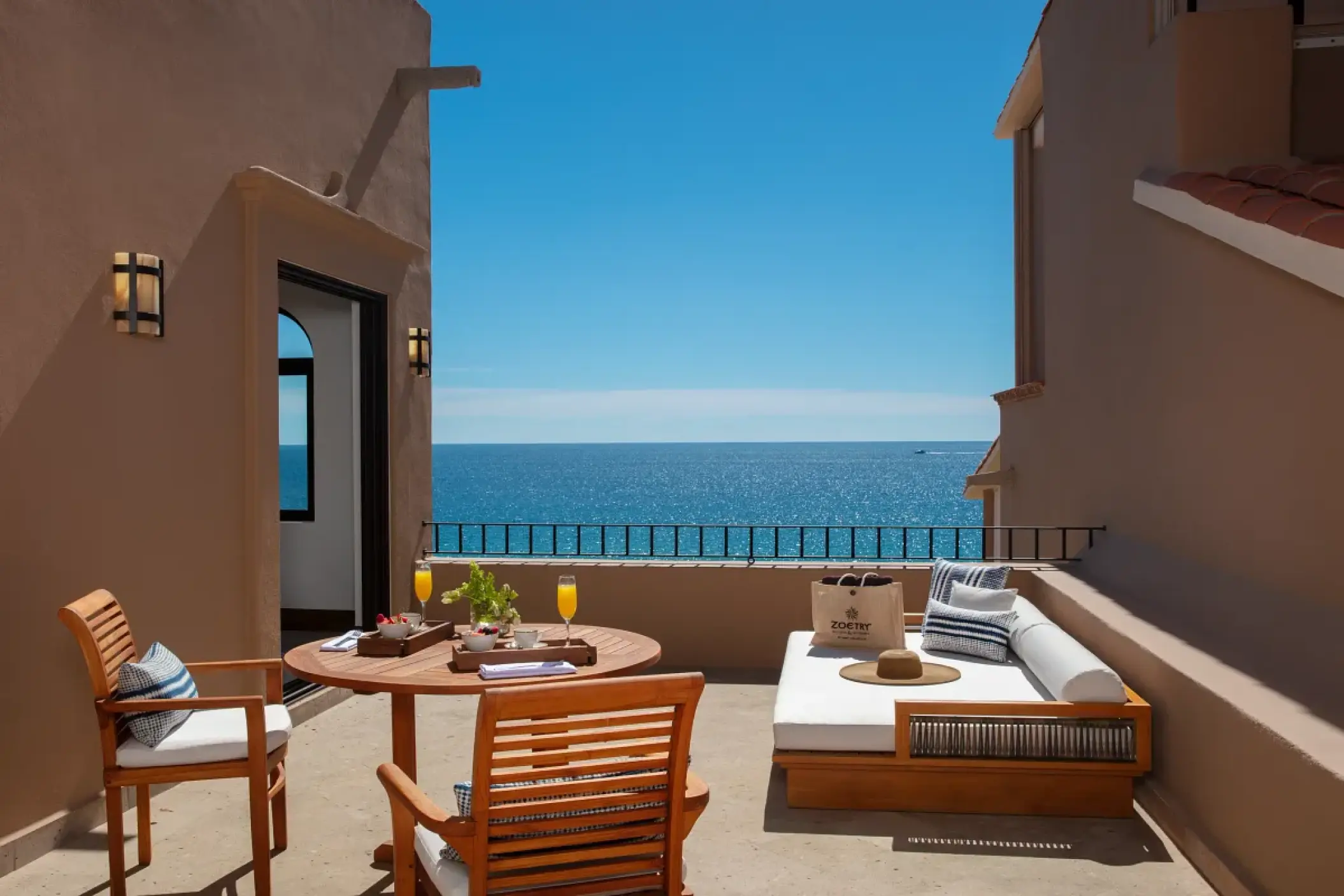 Private ocean-view terrace with a daybed and dining table at Zoetry Casa del Mar, Cabo San Lucas