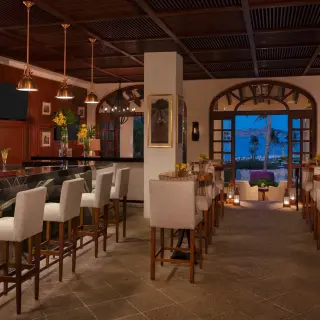 Maguey Bar with wood paneled walls and white barstools at Zoetry Casa del Mar, Cabo San Lucas