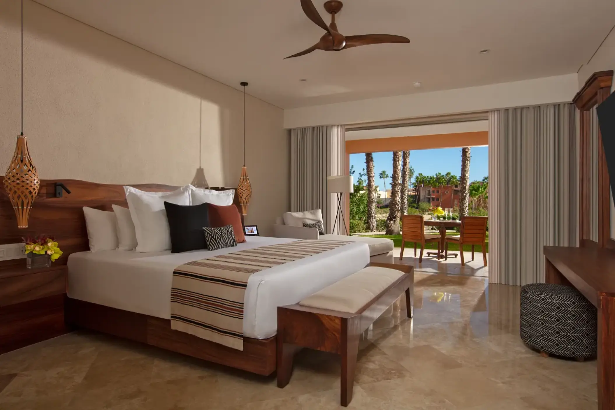 Ocean-view suite with wooden headboard and private terrace at Zoetry Casa del Mar, Cabo San Lucas