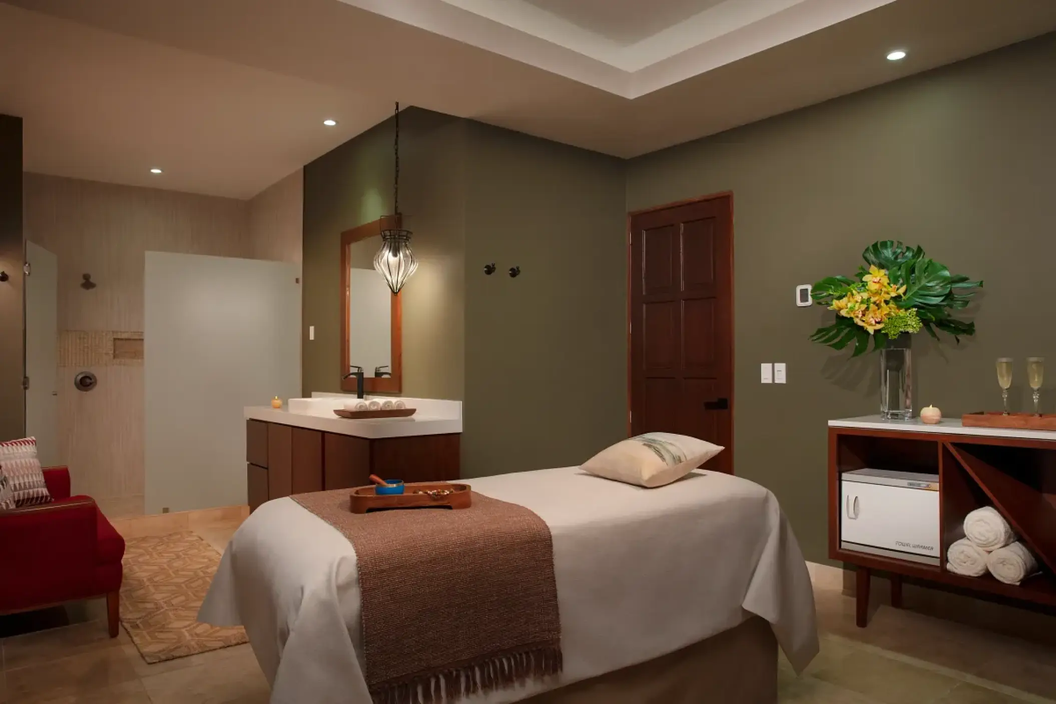 Spa treatment room with massage bed and vanity at Zoetry Casa del Mar, Cabo San Lucas
