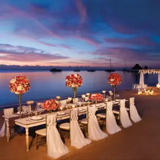 Beachfront wedding reception setup with floral centerpieces at Zoetry Paraiso de la Bonita, Riviera Maya