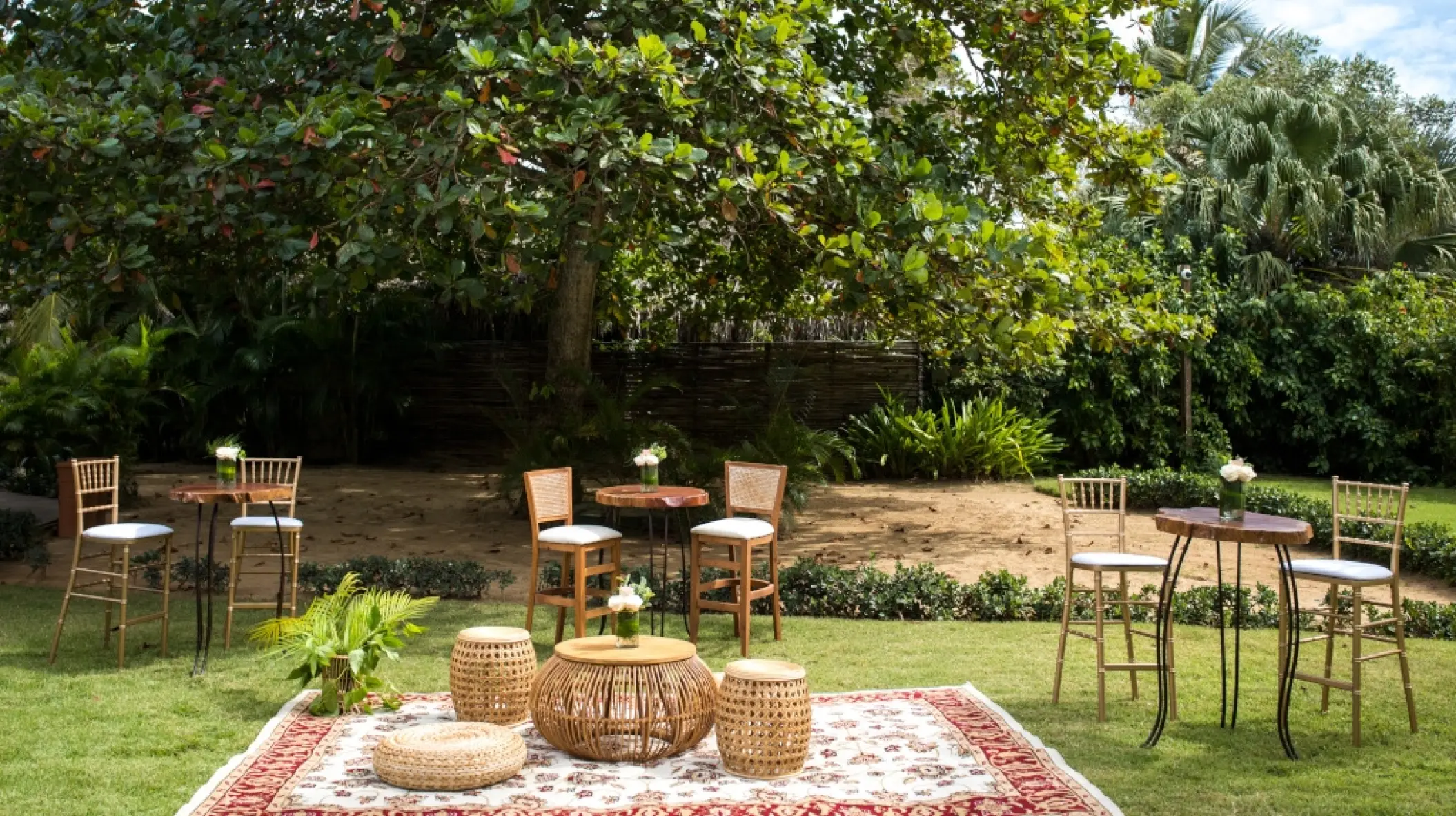 Outdoor cocktail hour lounge with woven furniture and tall bistro tables at Zoetry Agua, Punta Cana