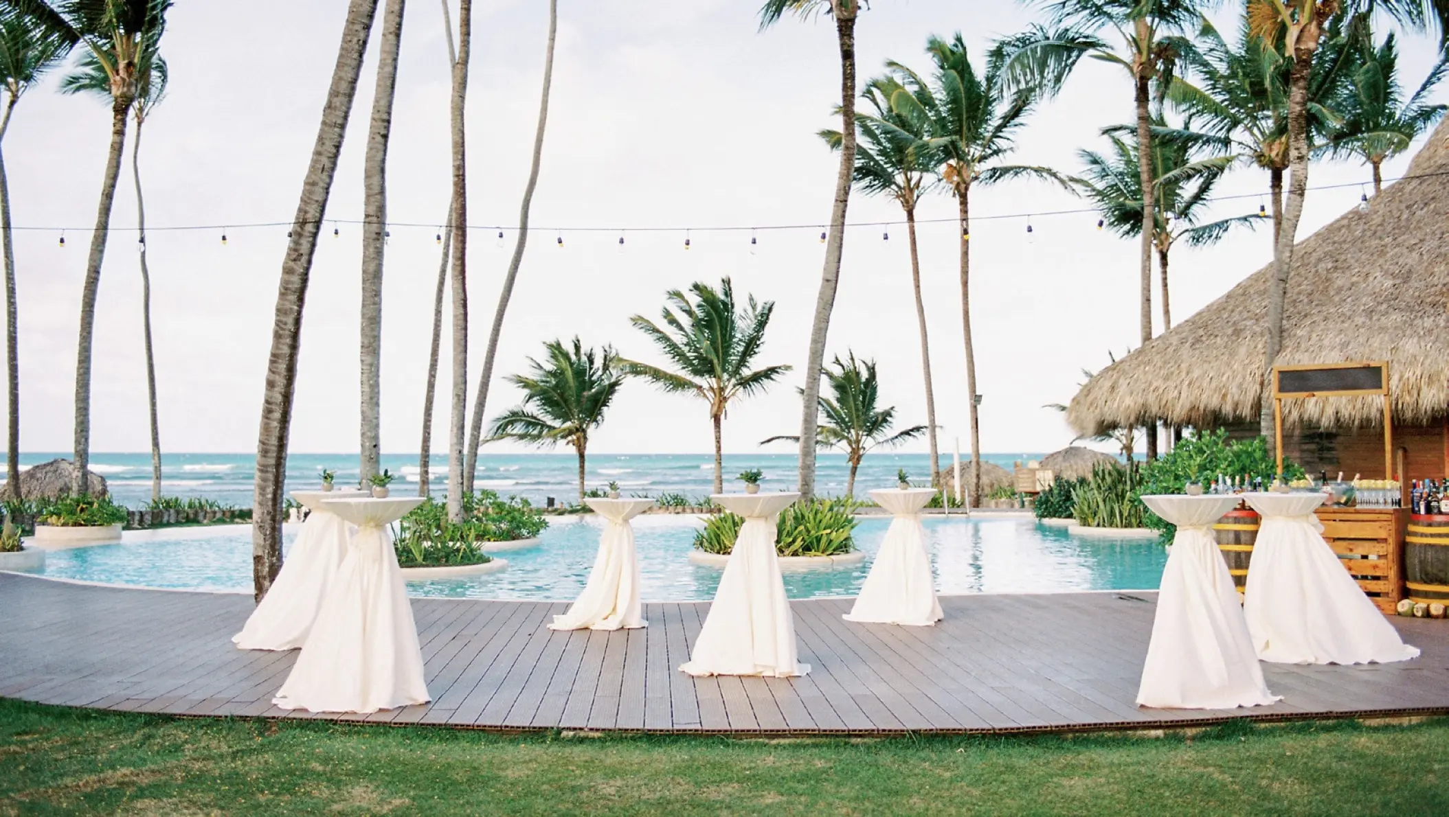 Wedding cocktail reception tables by the main pool at Zoetry Agua, Punta Cana