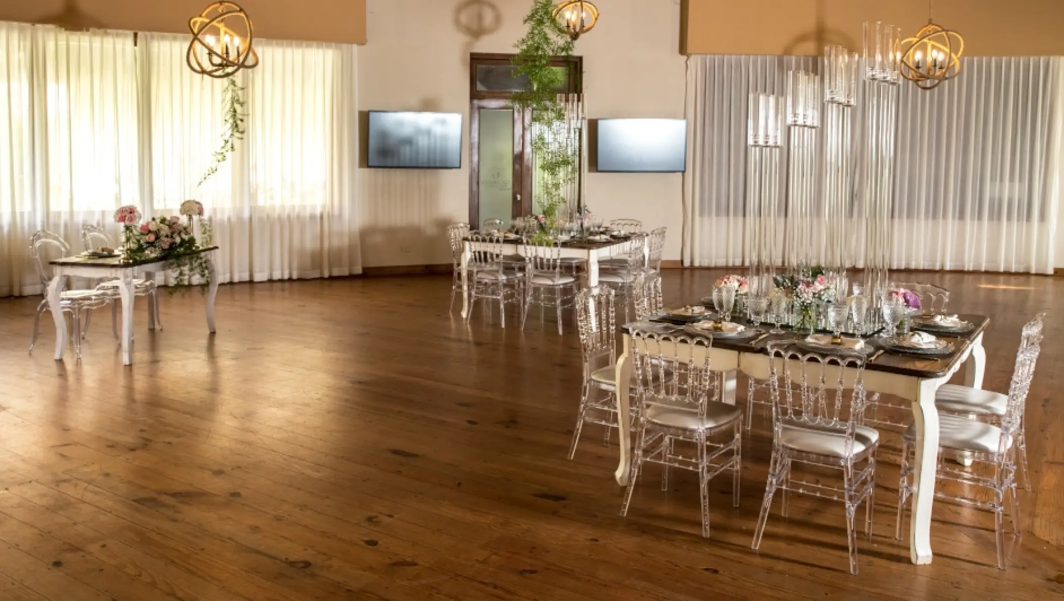 Indoor wedding reception with clear acrylic chairs and tall candles at Zoetry Agua, Punta Cana