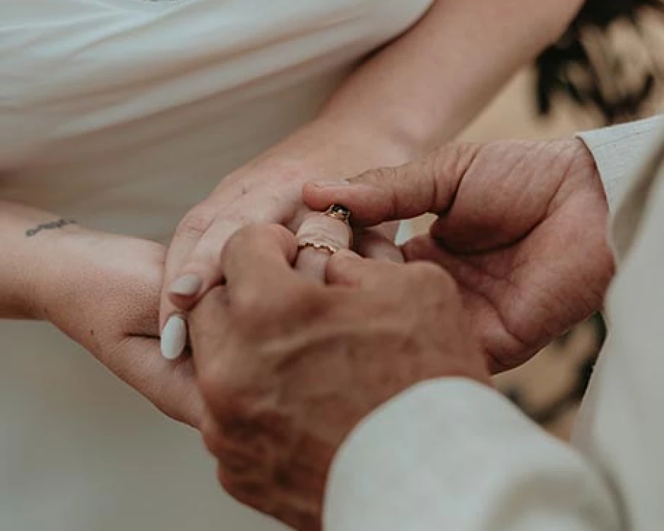 groom put the wedding band on his bride's finger