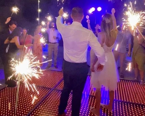 groom and bride's at their reception having fun with sparklers