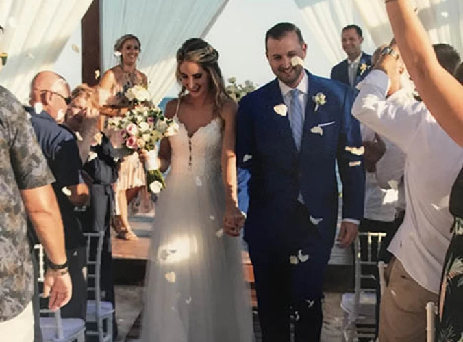 Groom and bride walking out of the isle in the middle of a flower petal rain