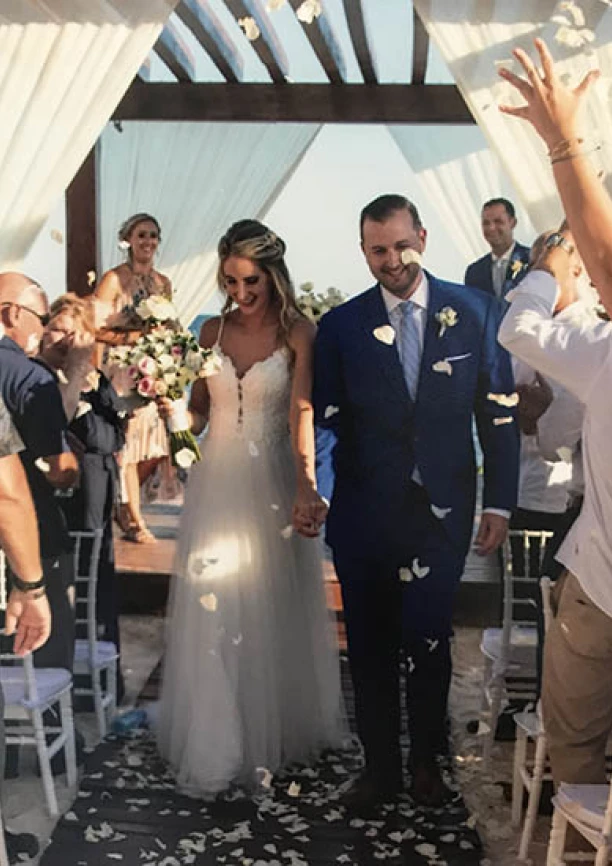 Groom and bride walking out of the isle in the middle of a flower petal rain