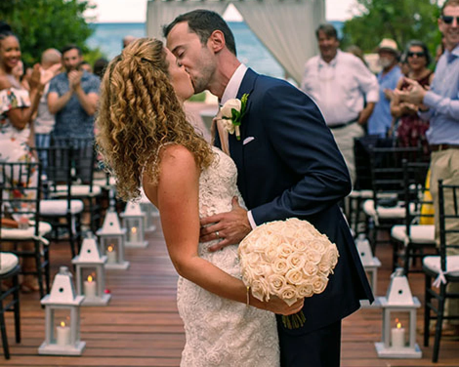 Bride and groom kisses in front of the isle