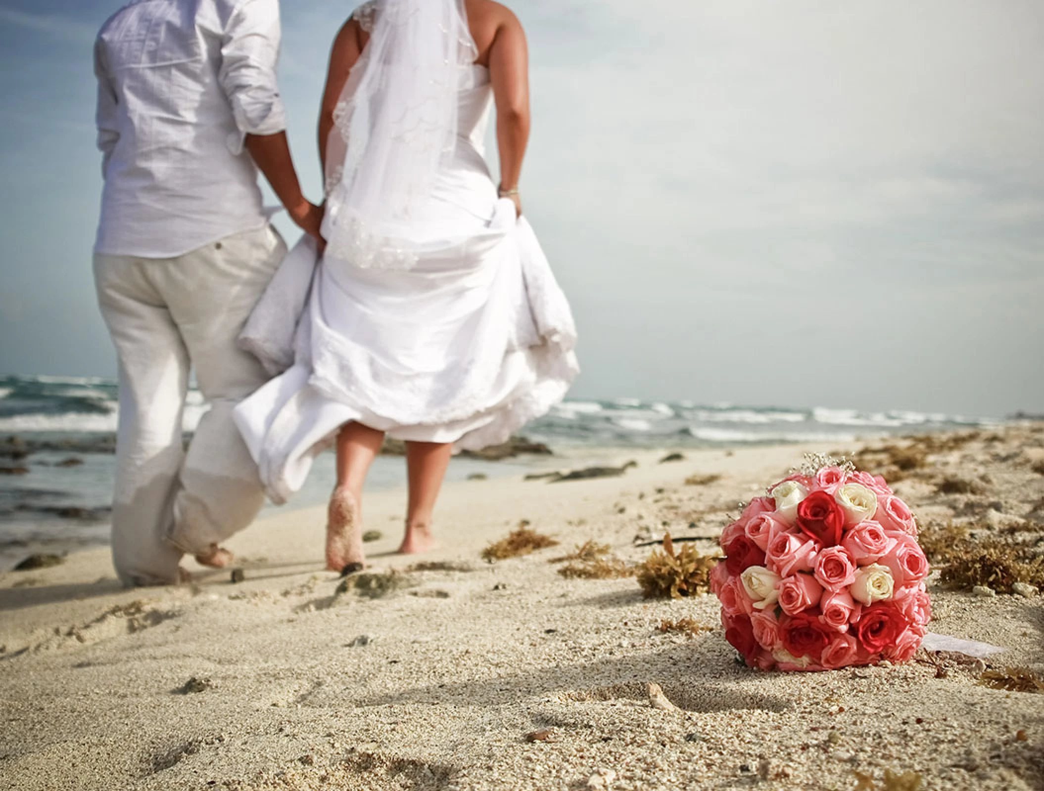 Just married Couple walking away at the beach.