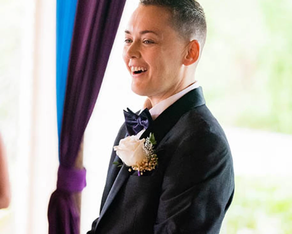 groom reacts smiling when looking at his bride for the first time