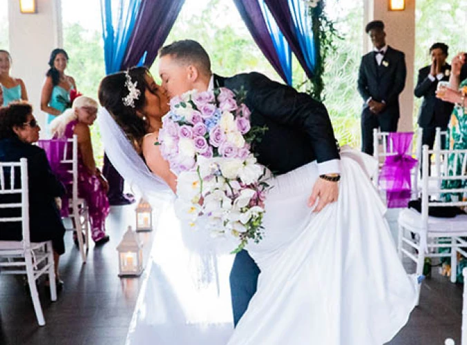 newlyweds kisses on front of the isle