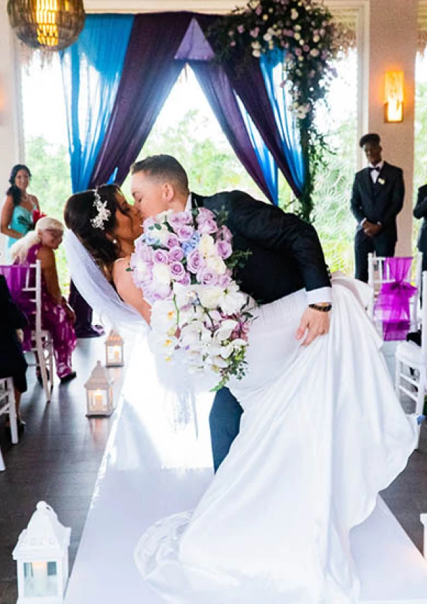 newlyweds kisses on front of the isle