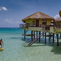 El Dorado Maroma over water bungalow with paddle-boarder