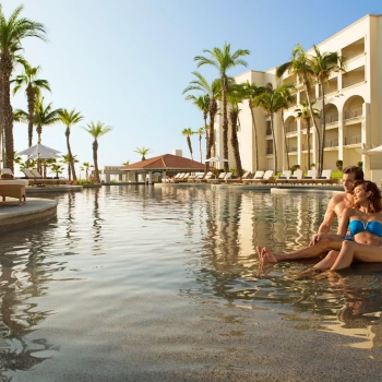 Couple on the main pool at Dreams Los Cabos Suites Golf Resort & Spa