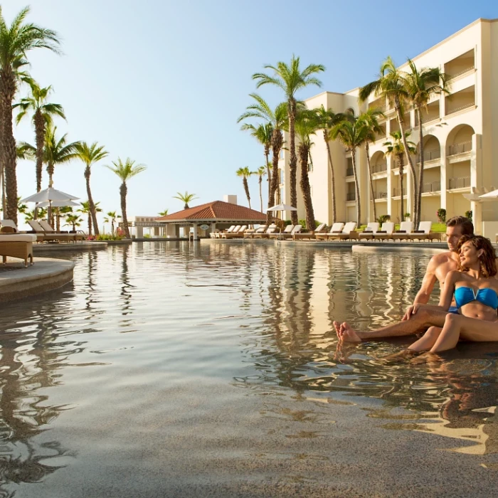 Couple on the main pool at Dreams Los Cabos Suites Golf Resort & Spa