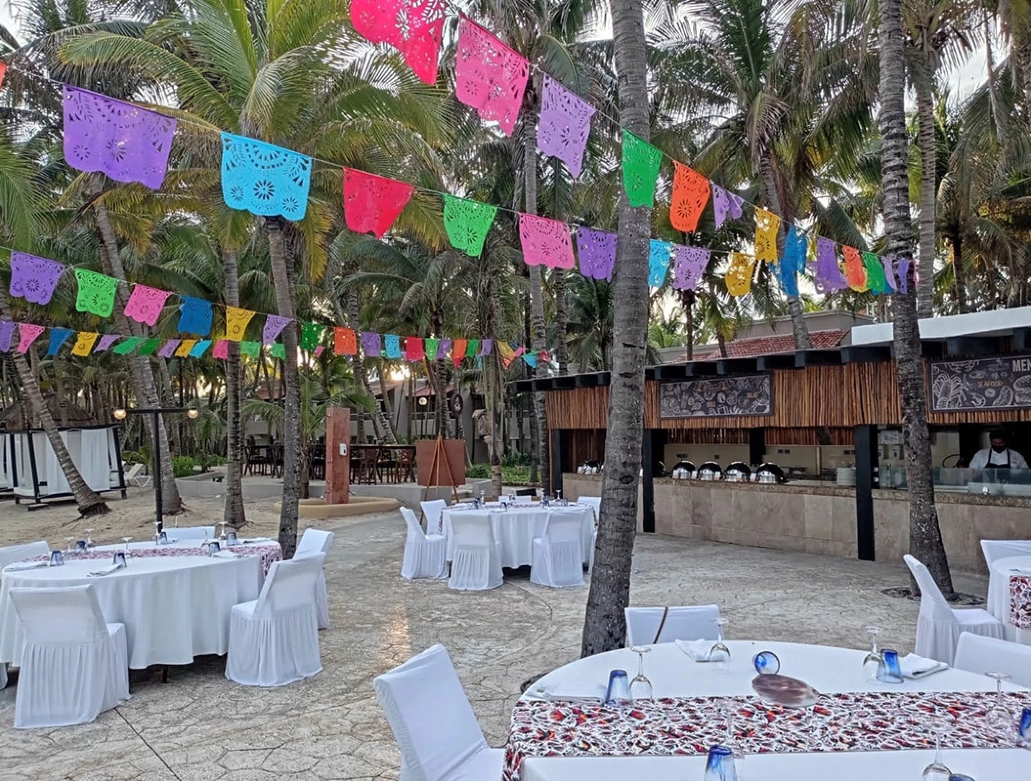 white gazebo soroundings with reception setup at El dorado Seaside Suites