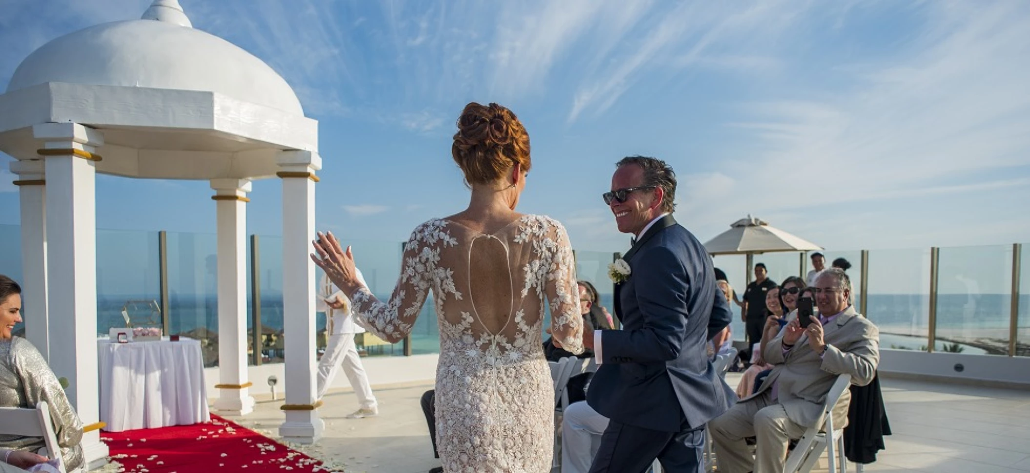 Couple marrying at Palafitos Sky deck venue at El dorado Maroma