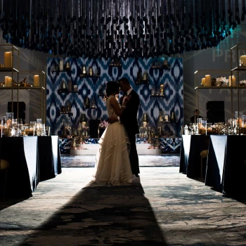 Couple embracing at heir wedding in the Grand Velas Los Cabos Resort ballroom