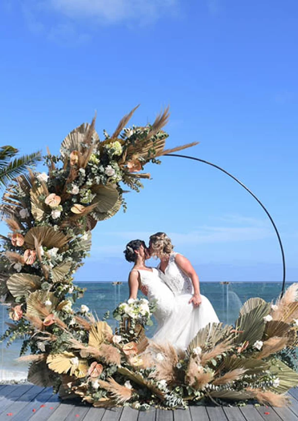 two newlywed brides kiss on a beautiful isle on the beach