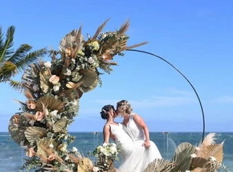 two newlywed brides kiss on a beautiful isle on the beach