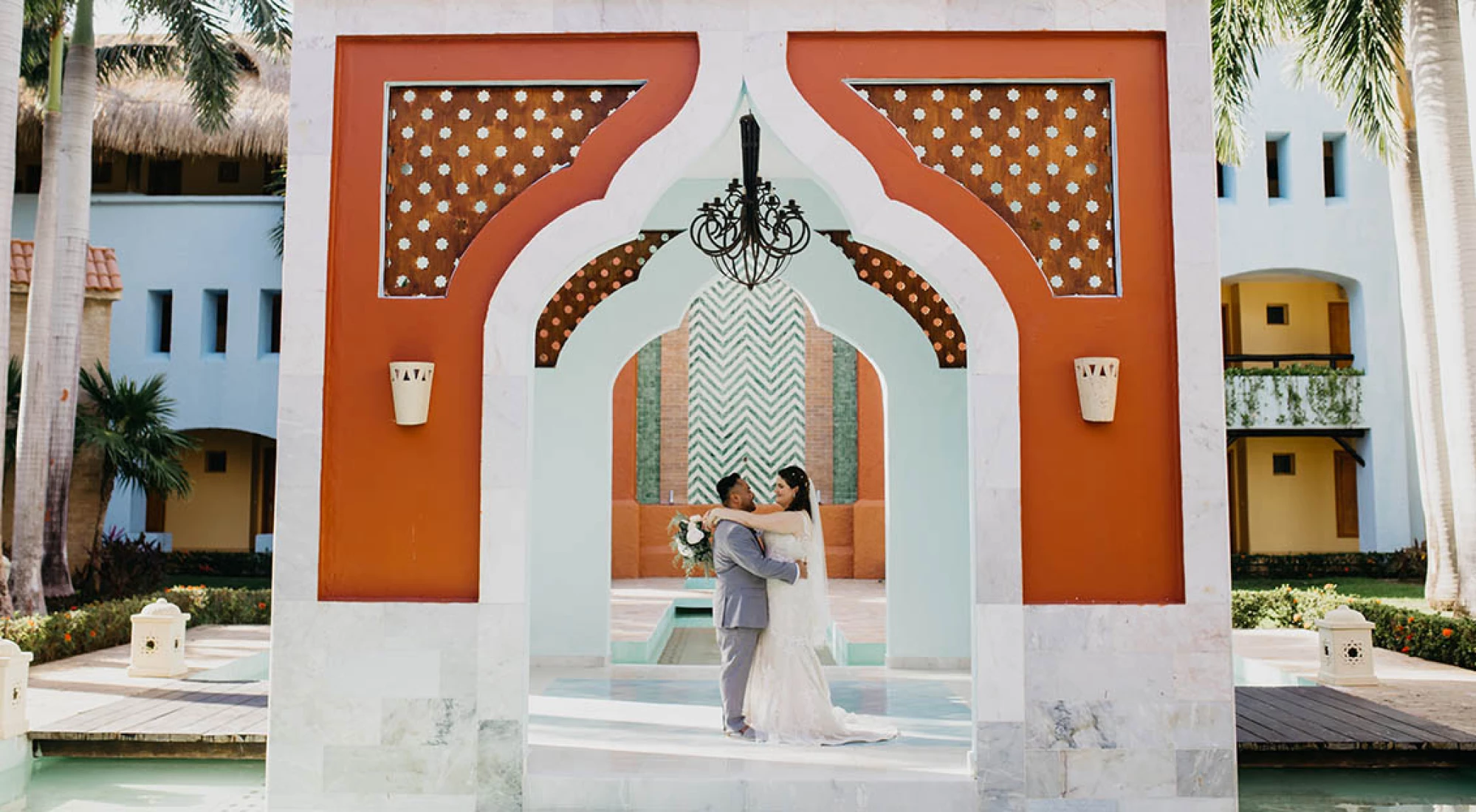 bride and groom underneath a beatiful mediterranean style arch