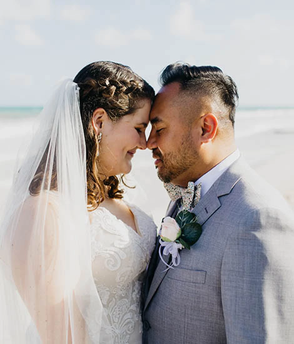 bride and groom looking at each other on the beach