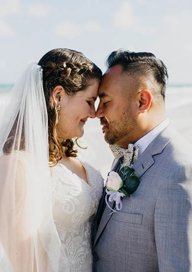 bride and groom looking at each other on the beach