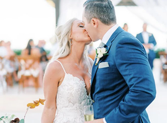 Bride kissing groom in front of the isle