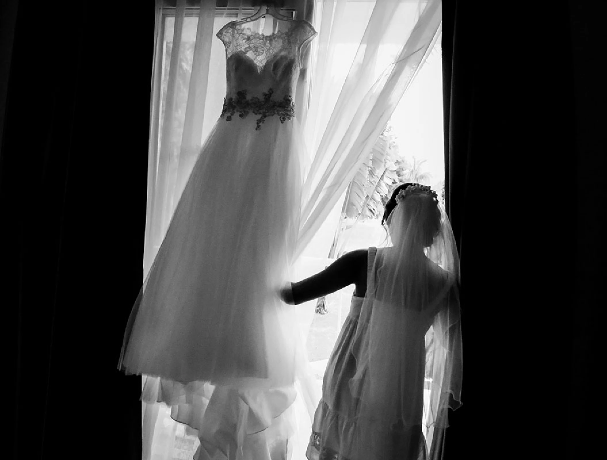 Bride Looking through the window while getting ready.