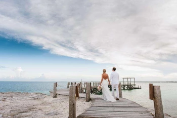 Couple walking throw The pier wedding venue at Nizuc Resort and Spa