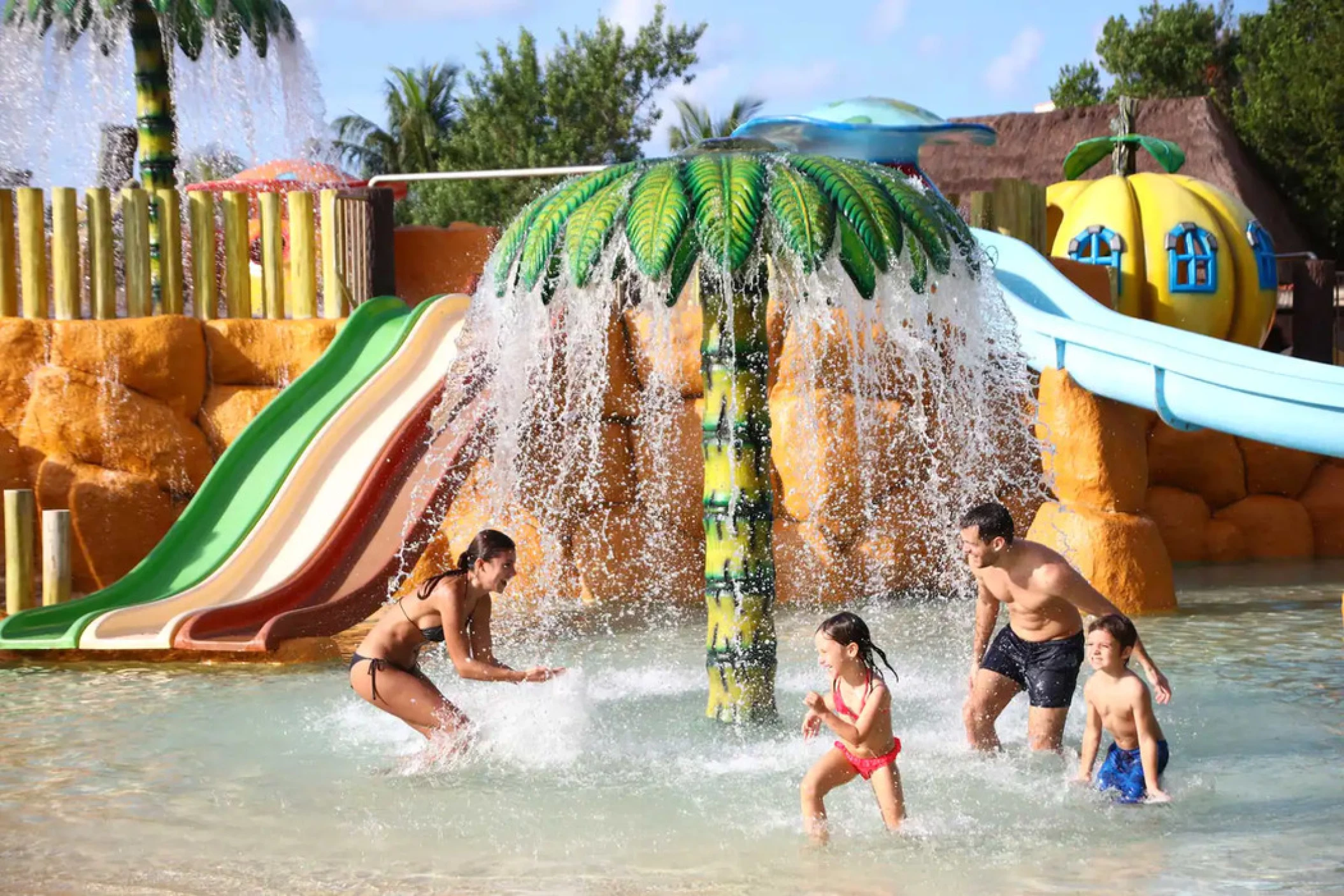 family of four having fun at the waterpark at Bahia Principe Grand Coba