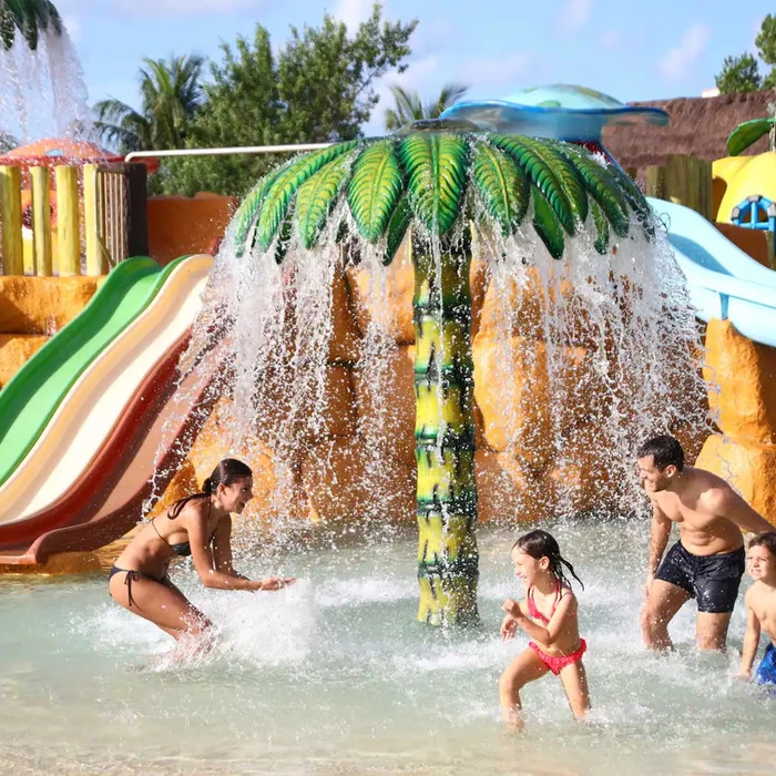 family of four having fun at the waterpark at Bahia Principe Grand Coba