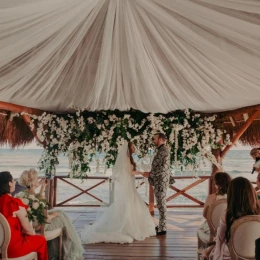 bride, groom, and guests at the overwater gazebo at Dreams Puerto Morelos Resort & Spa