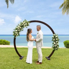 A bride and groom standing at the resort's West Lawn wedding venue with the ocean in the background.