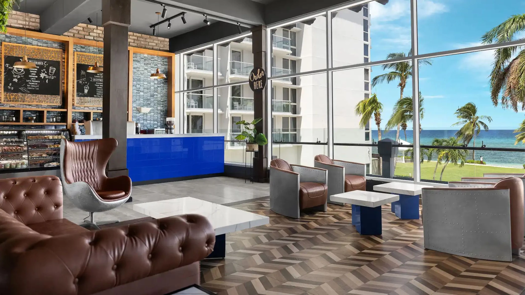 Inside the resort's coffee shop with large windows offering a beautiful view of the beach and ocean.