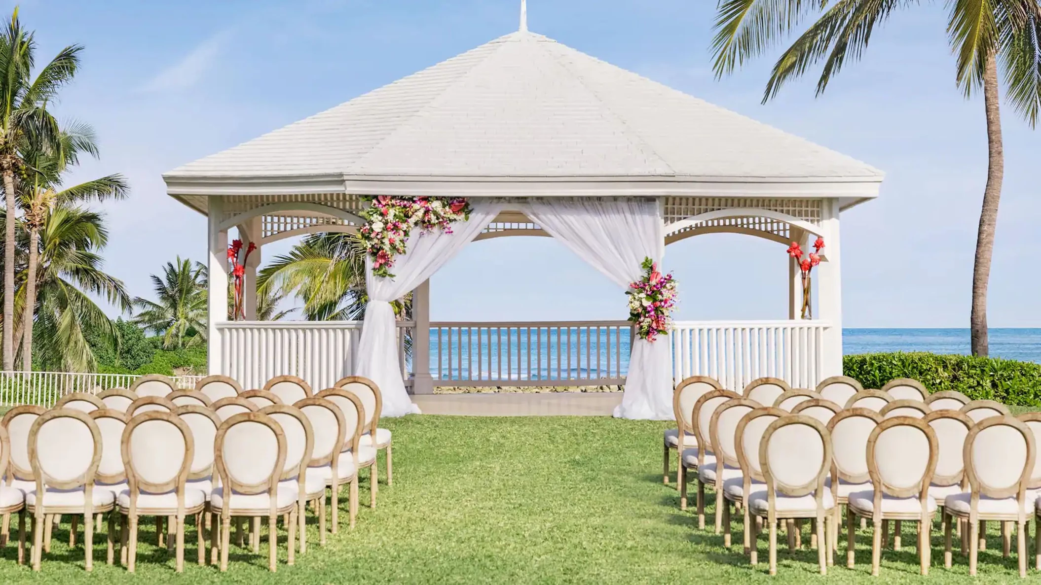 A charming gazebo wedding venue at the resort, decorated with flowers and overlooking the stunning ocean.