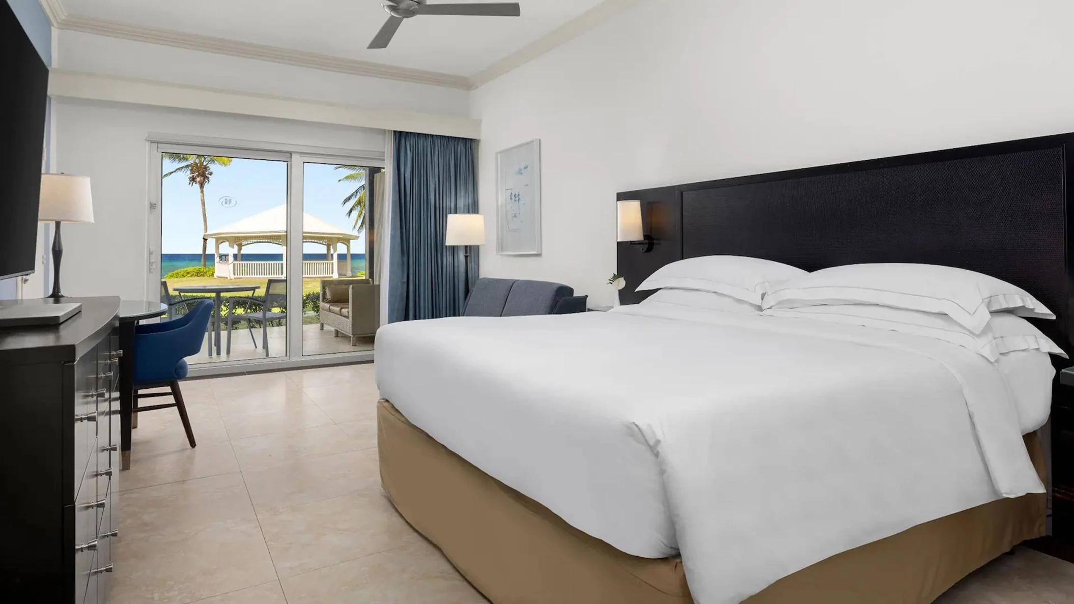 An Oceanfront Walkout King room with a large bed and direct access to a private patio and the lawn.