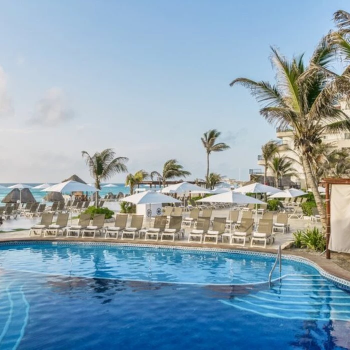 pool loungers and the beach at Fiesta Americana Condesa Cancun