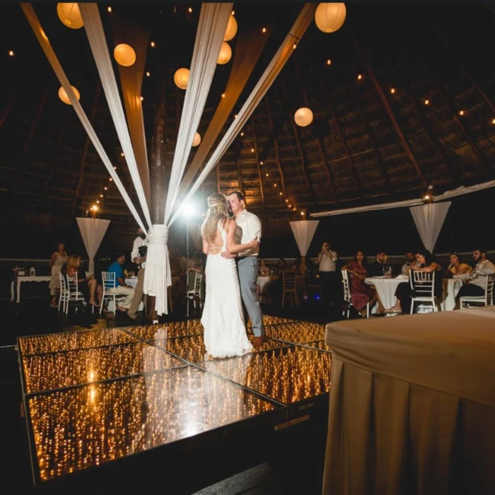 bride and groom on the dance floor, with string lights, and paper lanterns at Grand Sirenis Riviera Maya