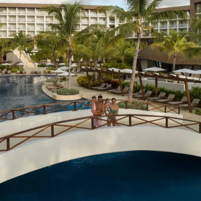 family standing on a bridge over a pool at Hyatt Ziva Cap Cana