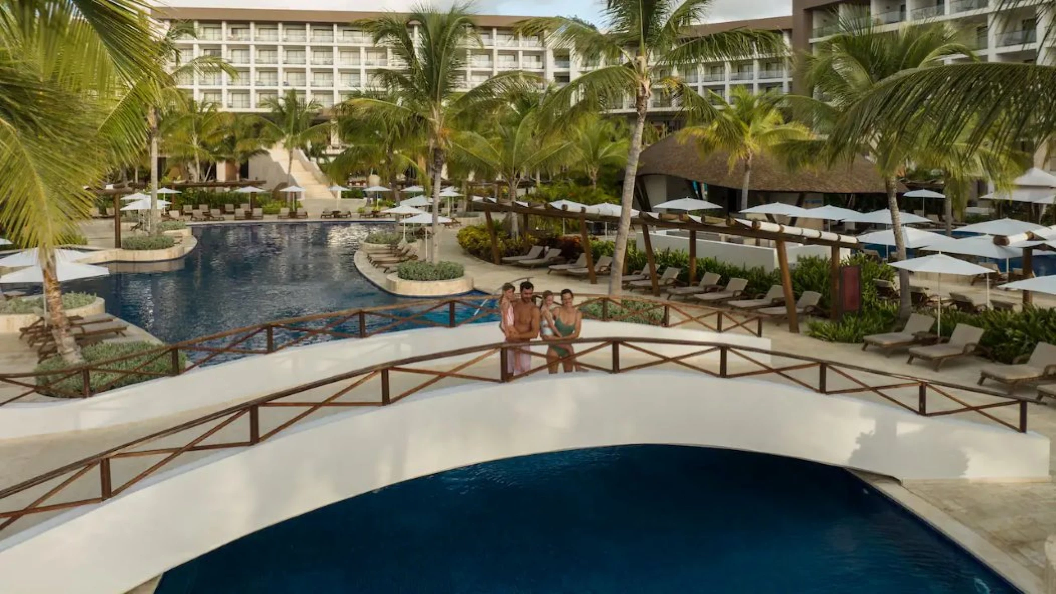 family standing on a bridge over a pool at Hyatt Ziva Cap Cana