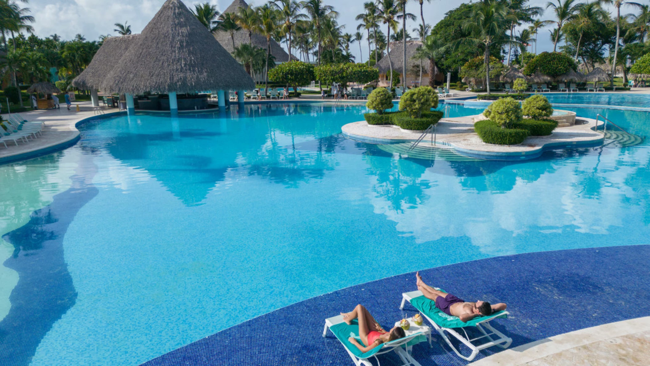 couple lounging by the pool at Iberostar Selection Hacienda Dominicus